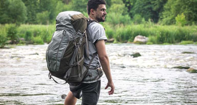 A hiker with a large hiking backpack on a hike.